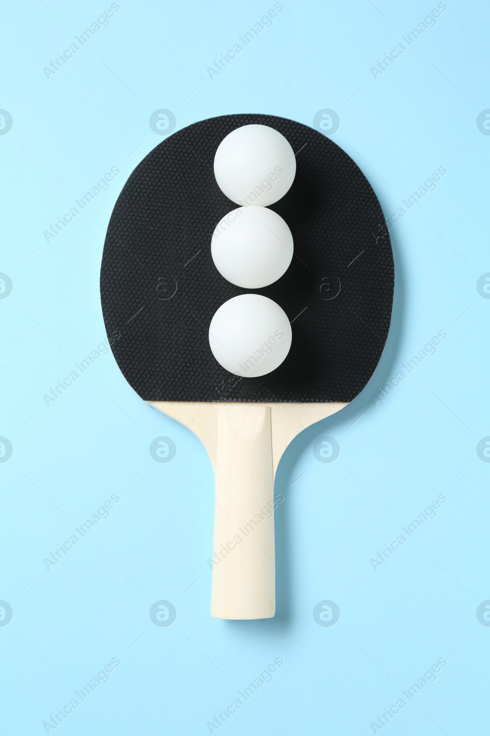 Ping pong racket and balls on light blue background, top view Photo of Ping pong racket and balls on light blue background, top view