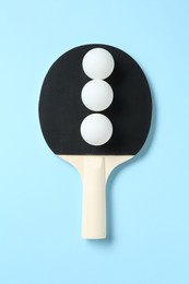 Photo of Ping pong racket and balls on light blue background, top view