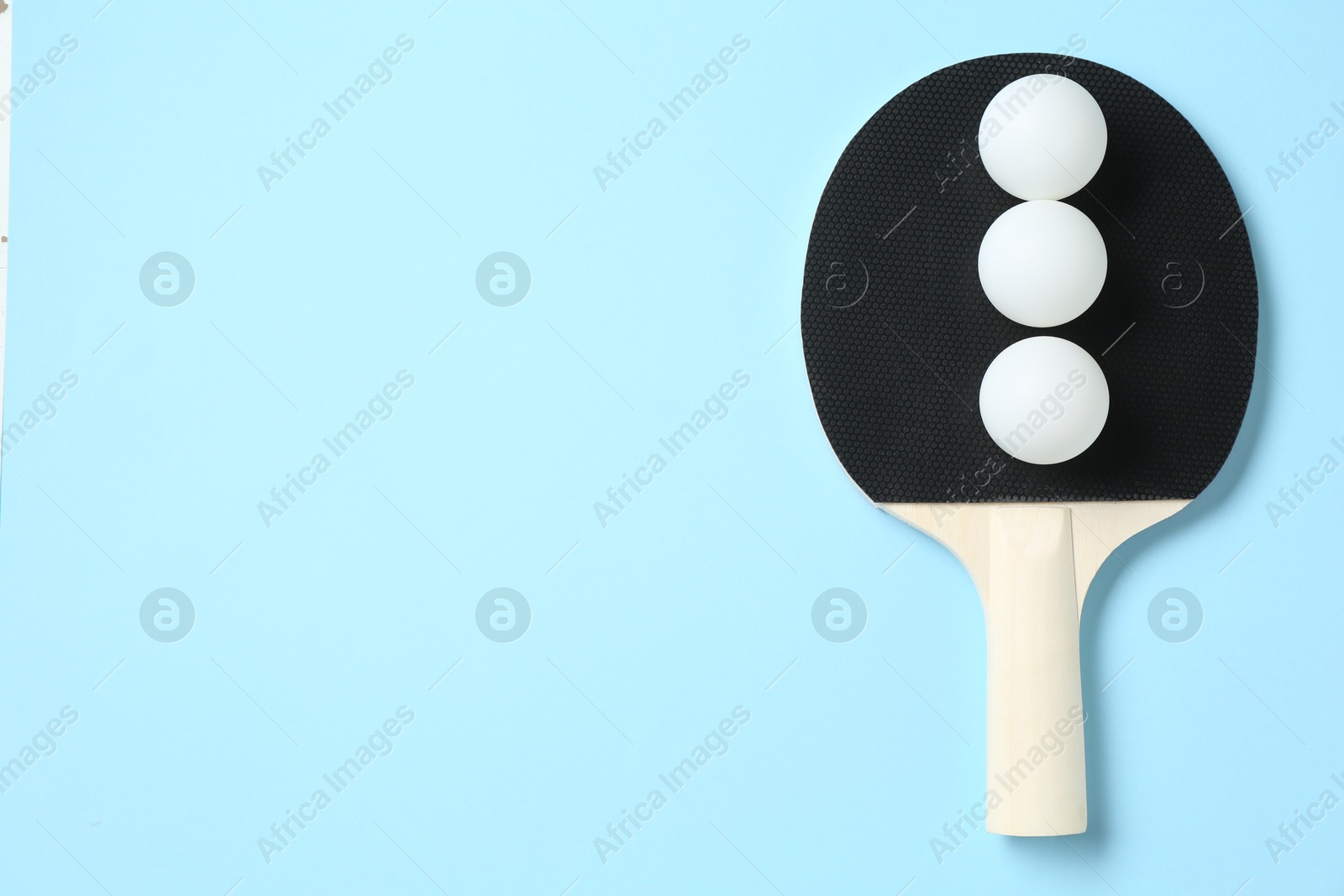 Ping pong racket and balls on light blue background, top view. Space for text Photo of Ping pong racket and balls on light blue background, top view. Space for text