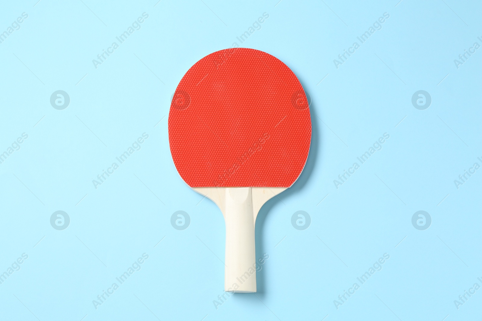 One ping pong racket on light blue background, top view Photo of One ping pong racket on light blue background, top view
