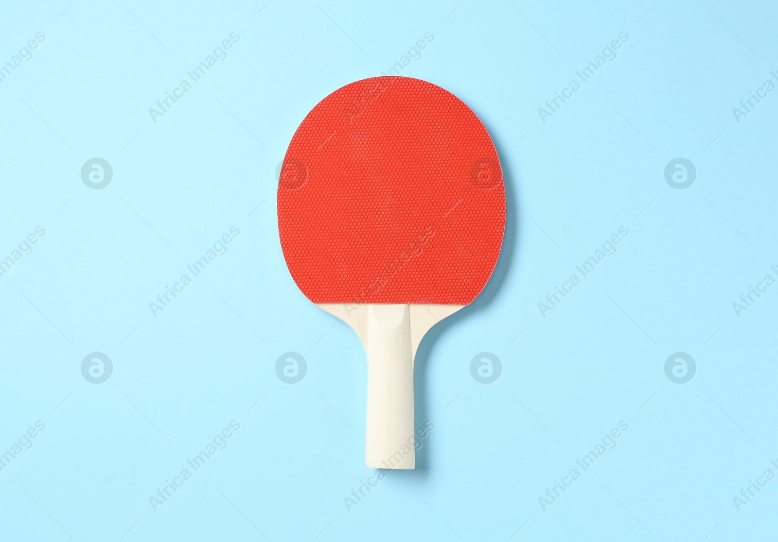 One ping pong racket on light blue background, top view Photo of One ping pong racket on light blue background, top view