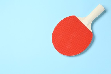 Photo of One ping pong racket on light blue background, top view. Space for text