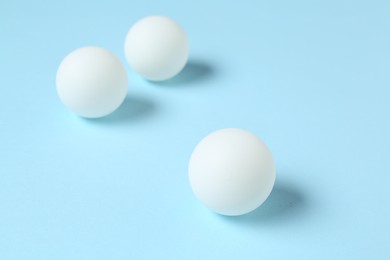 Photo of Ping pong balls on light blue background, closeup