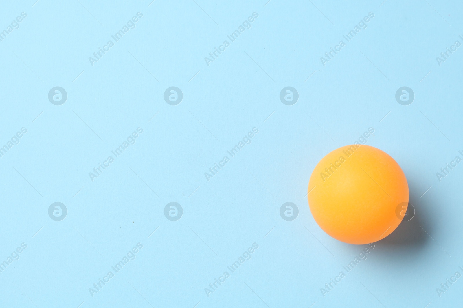 Ping pong ball on light blue background, top view. Space for text Photo of Ping pong ball on light blue background, top view. Space for text