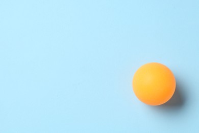 Photo of Ping pong ball on light blue background, top view. Space for text