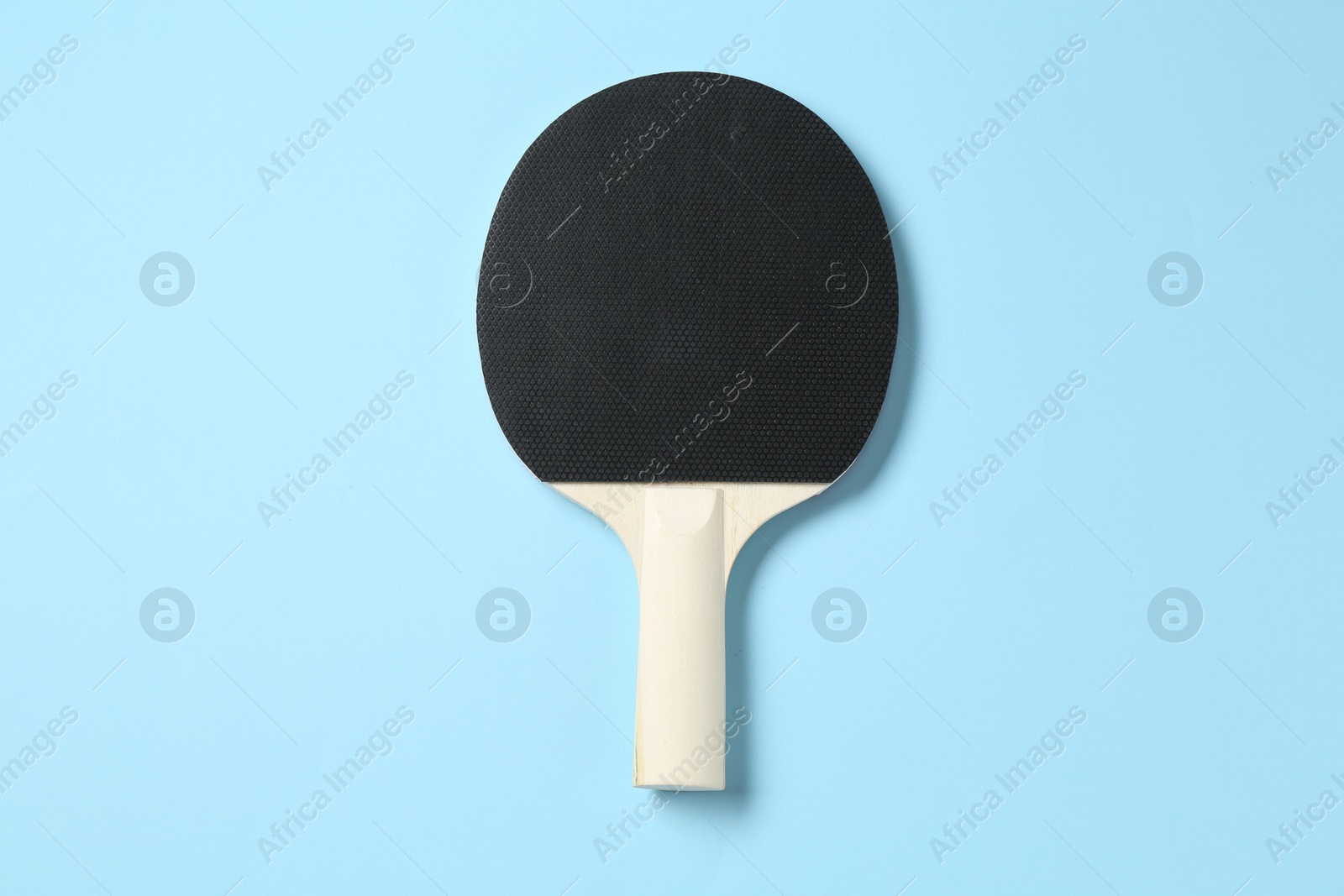 Ping pong racket on light blue background, top view Photo of Ping pong racket on light blue background, top view
