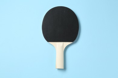 Photo of Ping pong racket on light blue background, top view
