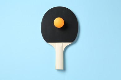 Photo of Ping pong racket and ball on light blue background, top view