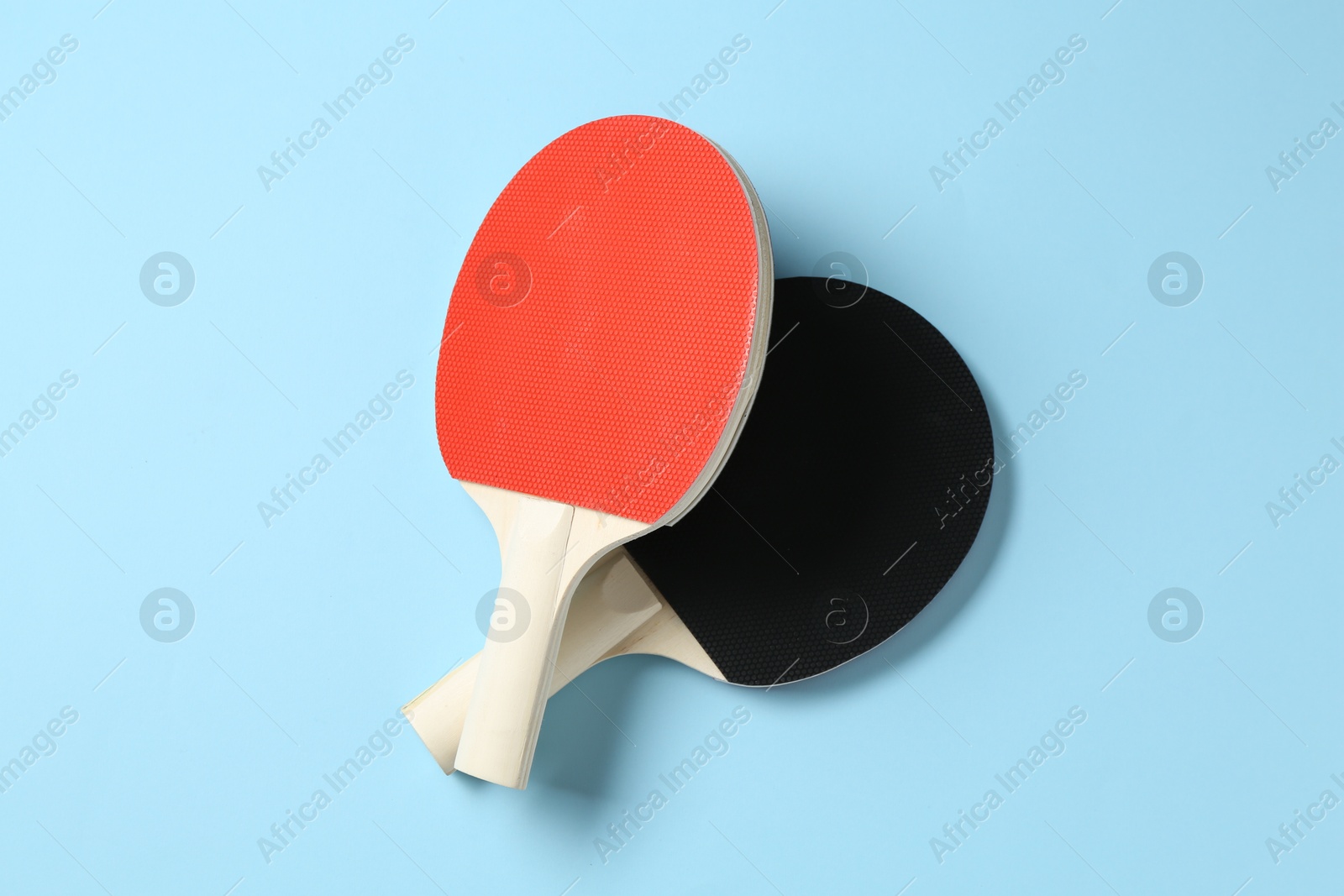 Ping pong rackets on light blue background, flat lay Photo of Ping pong rackets on light blue background, flat lay