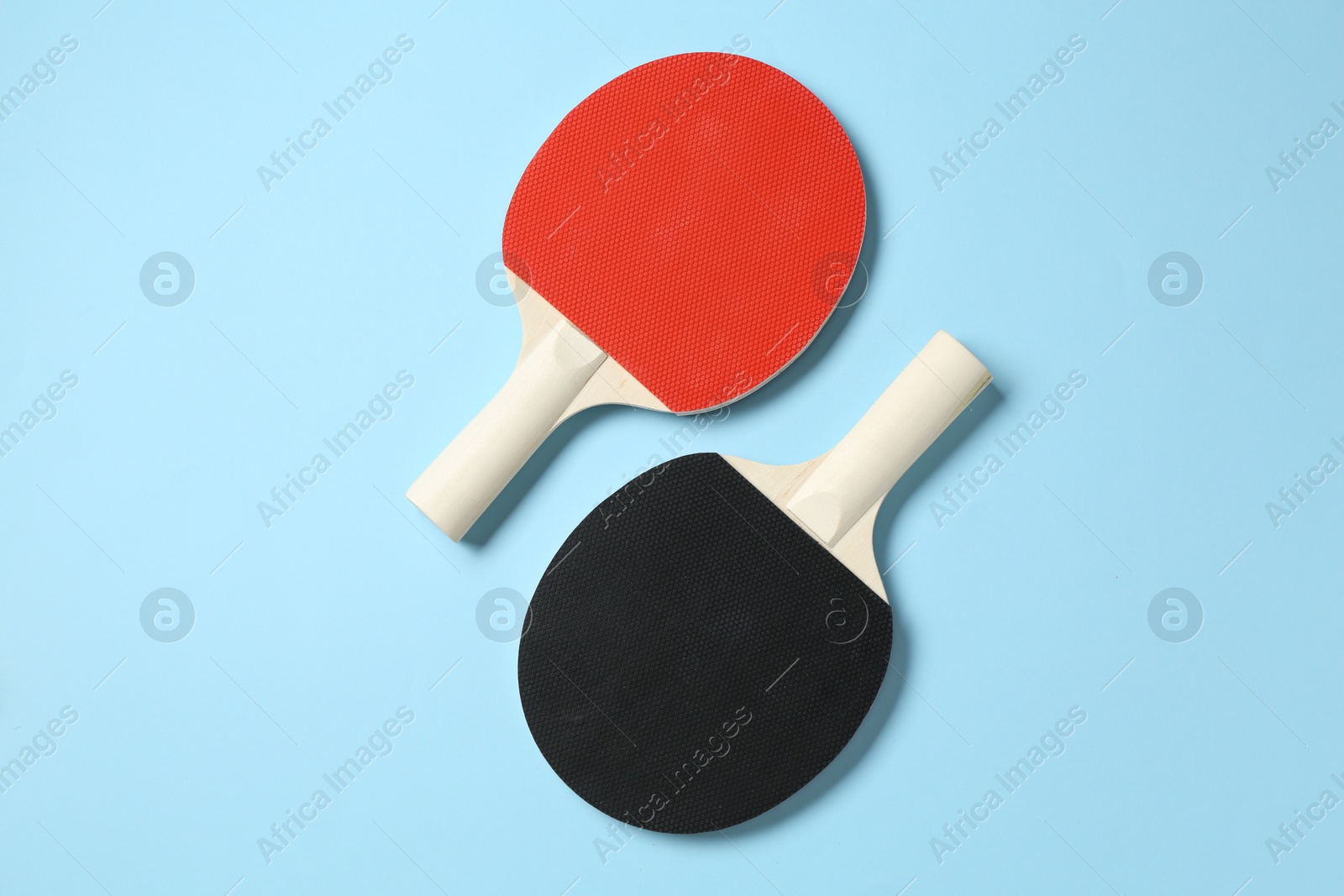 Ping pong rackets on light blue background, flat lay Photo of Ping pong rackets on light blue background, flat lay