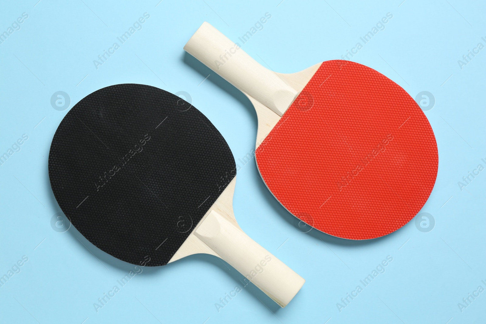 Ping pong rackets on light blue background, flat lay Photo of Ping pong rackets on light blue background, flat lay