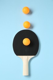 Photo of Ping pong racket and balls on light blue background, flat lay