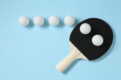 Photo of Ping pong racket and balls on light blue background, flat lay