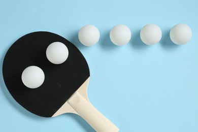 Photo of Ping pong racket and balls on light blue background, flat lay