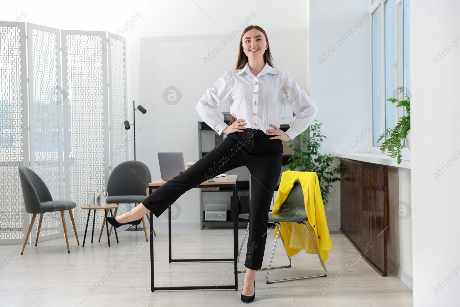 Beautiful woman doing exercise near desk in office Photo of Beautiful woman doing exercise near desk in office