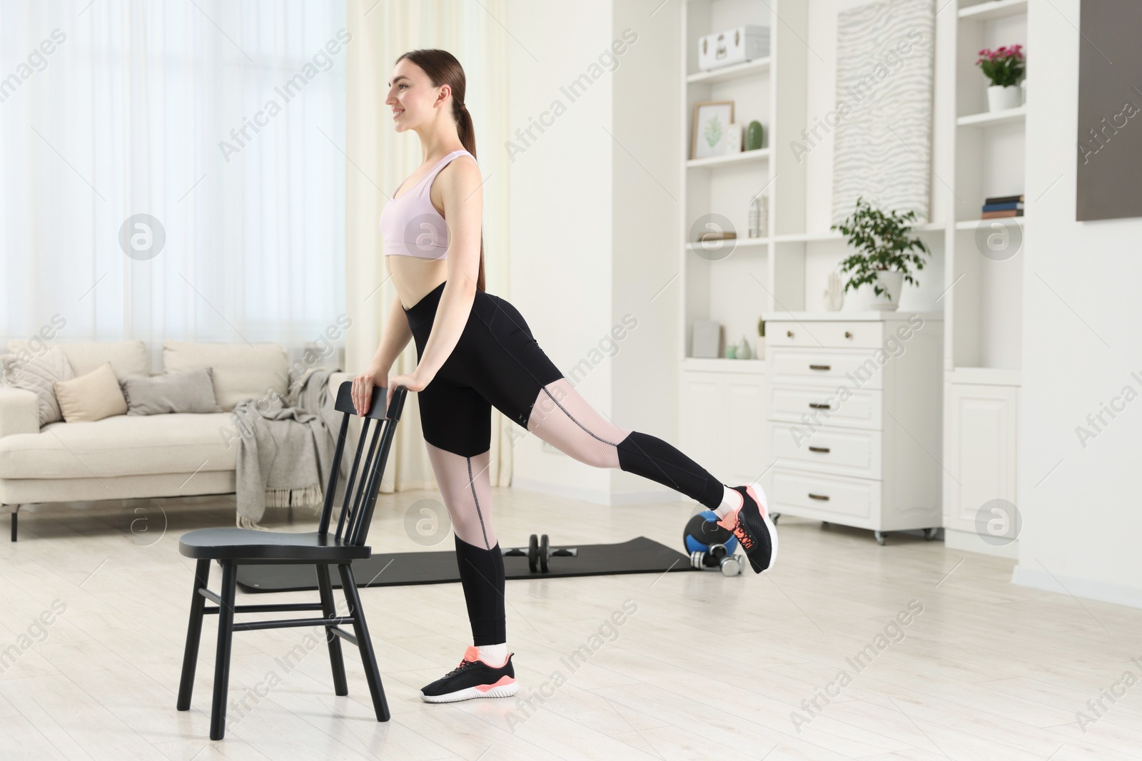 Beautiful woman exercising with chair at home Photo of Beautiful woman exercising with chair at home