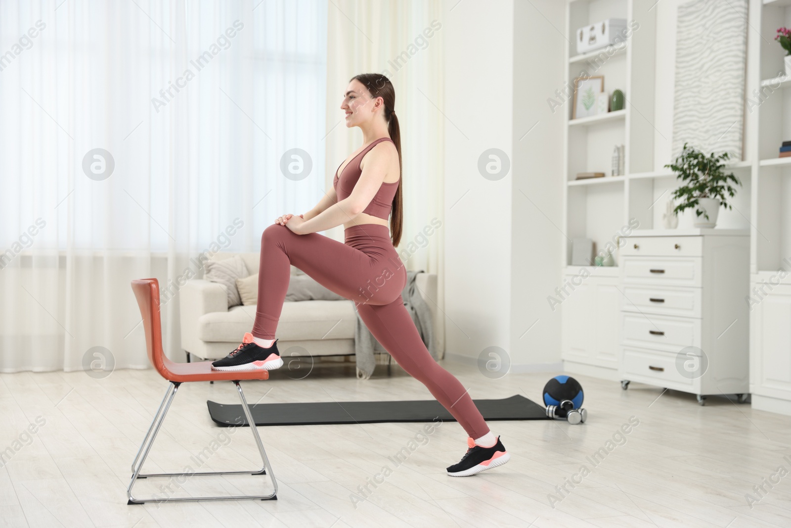Beautiful woman exercising with chair at home Photo of Beautiful woman exercising with chair at home