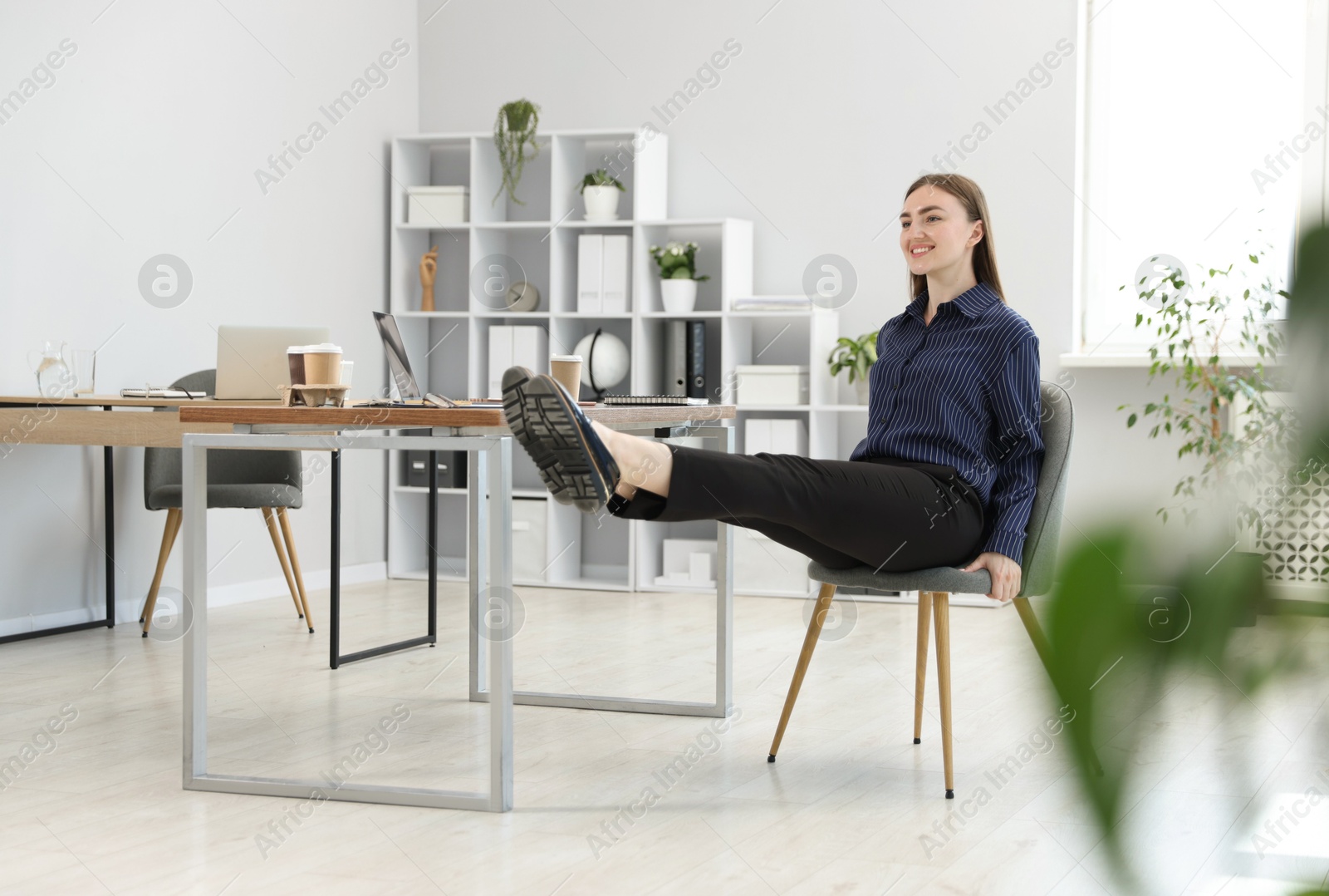 Beautiful woman exercising with chair in office Photo of Beautiful woman exercising with chair in office