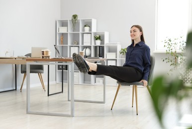 Photo of Beautiful woman exercising with chair in office