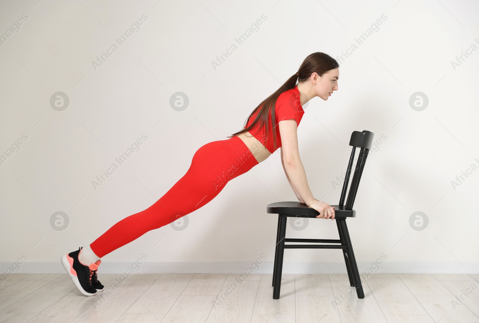 Beautiful woman exercising with chair at home Photo of Beautiful woman exercising with chair at home