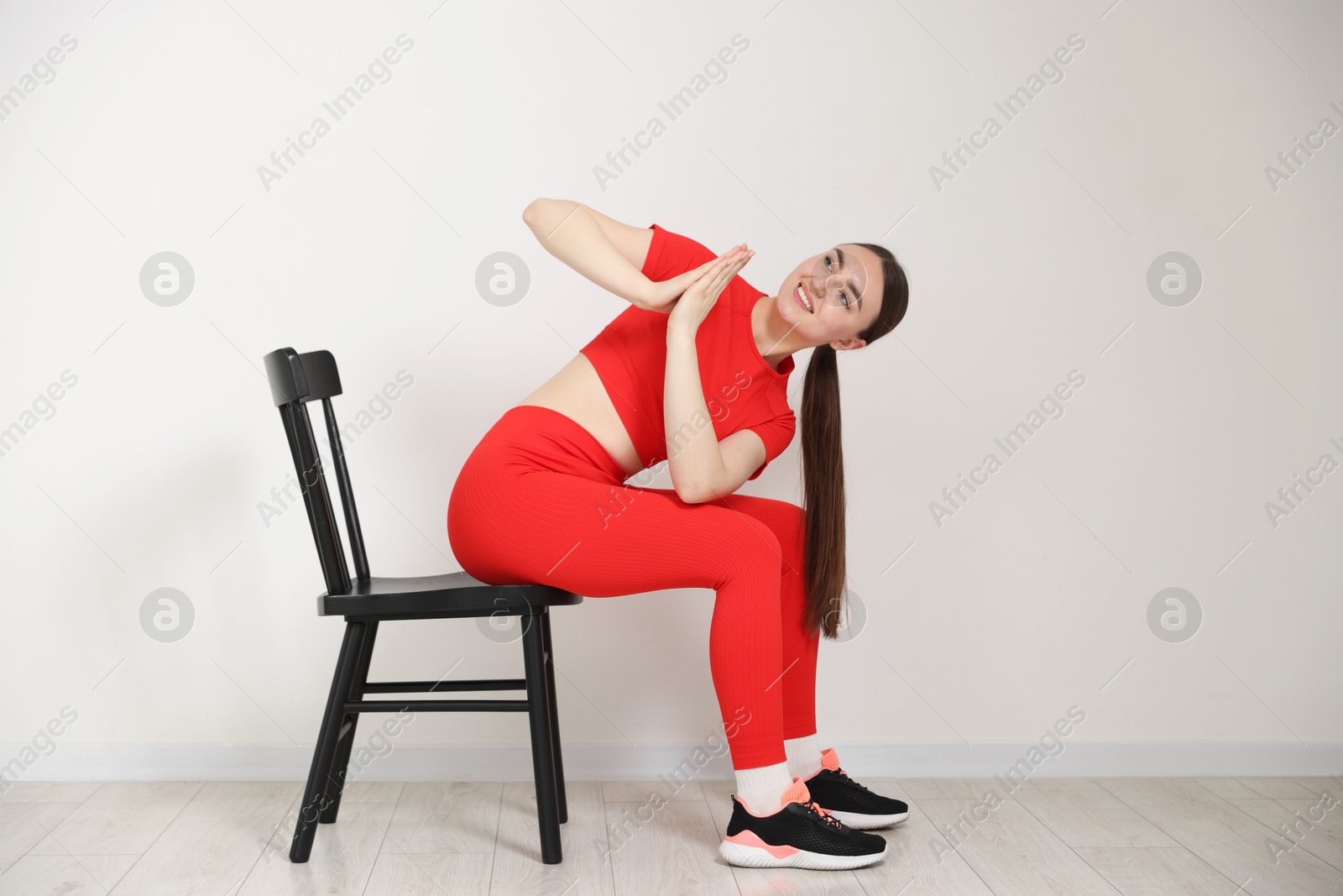 Beautiful woman stretching on chair at home Photo of Beautiful woman stretching on chair at home