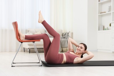Photo of Beautiful woman exercising with chair at home