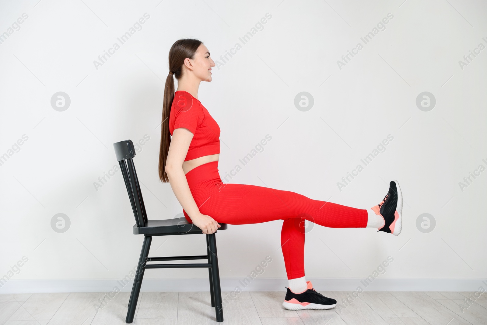 Beautiful woman exercising with chair at home Photo of Beautiful woman exercising with chair at home