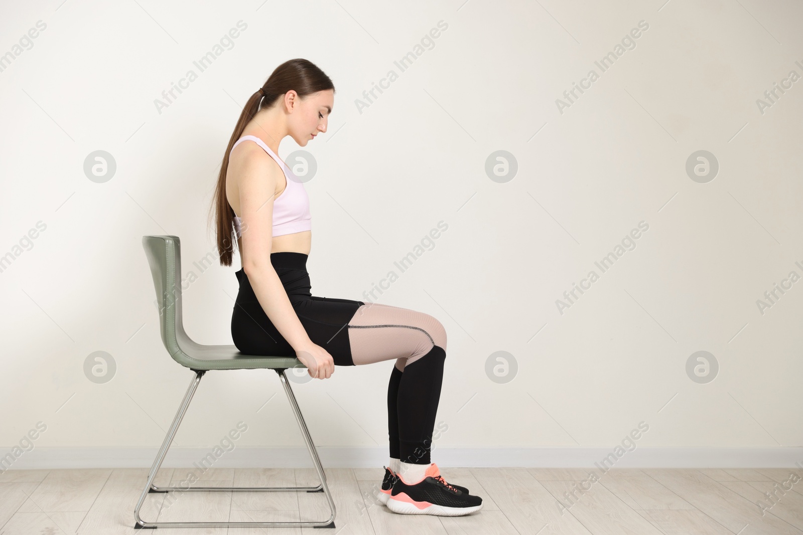 Beautiful woman stretching on chair at home, space for text Photo of Beautiful woman stretching on chair at home, space for text