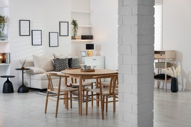 Photo of Table, chairs and comfortable sofa indoors. Interior design