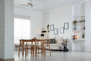 Photo of Table, chairs and comfortable sofa indoors. Interior design