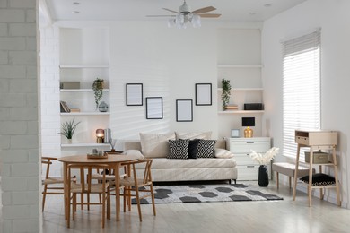 Photo of Comfortable sofa, table, chairs and dresser indoors. Interior design