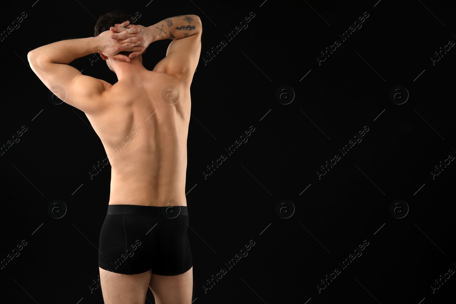 Young man in stylish underwear on black background, back view. Space for text Photo of Young man in stylish underwear on black background, back view. Space for text