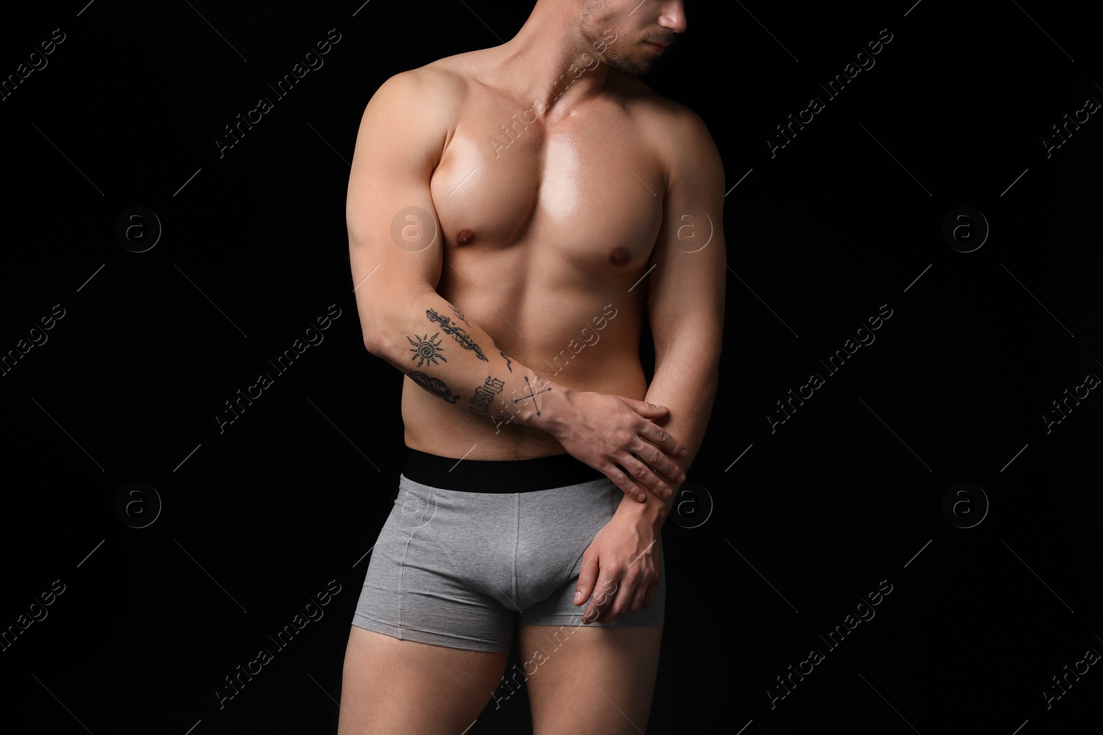 Young man in stylish light grey underwear on black background, closeup Photo of Young man in stylish light grey underwear on black background, closeup
