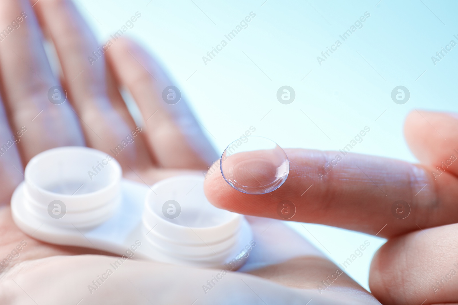 Woman with contact lenses on light blue background, closeup Photo of Woman with contact lenses on light blue background, closeup