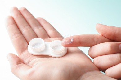 Photo of Woman with contact lenses on light background, closeup