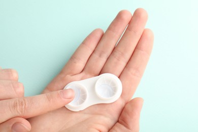 Photo of Woman with contact lenses on light blue background, closeup