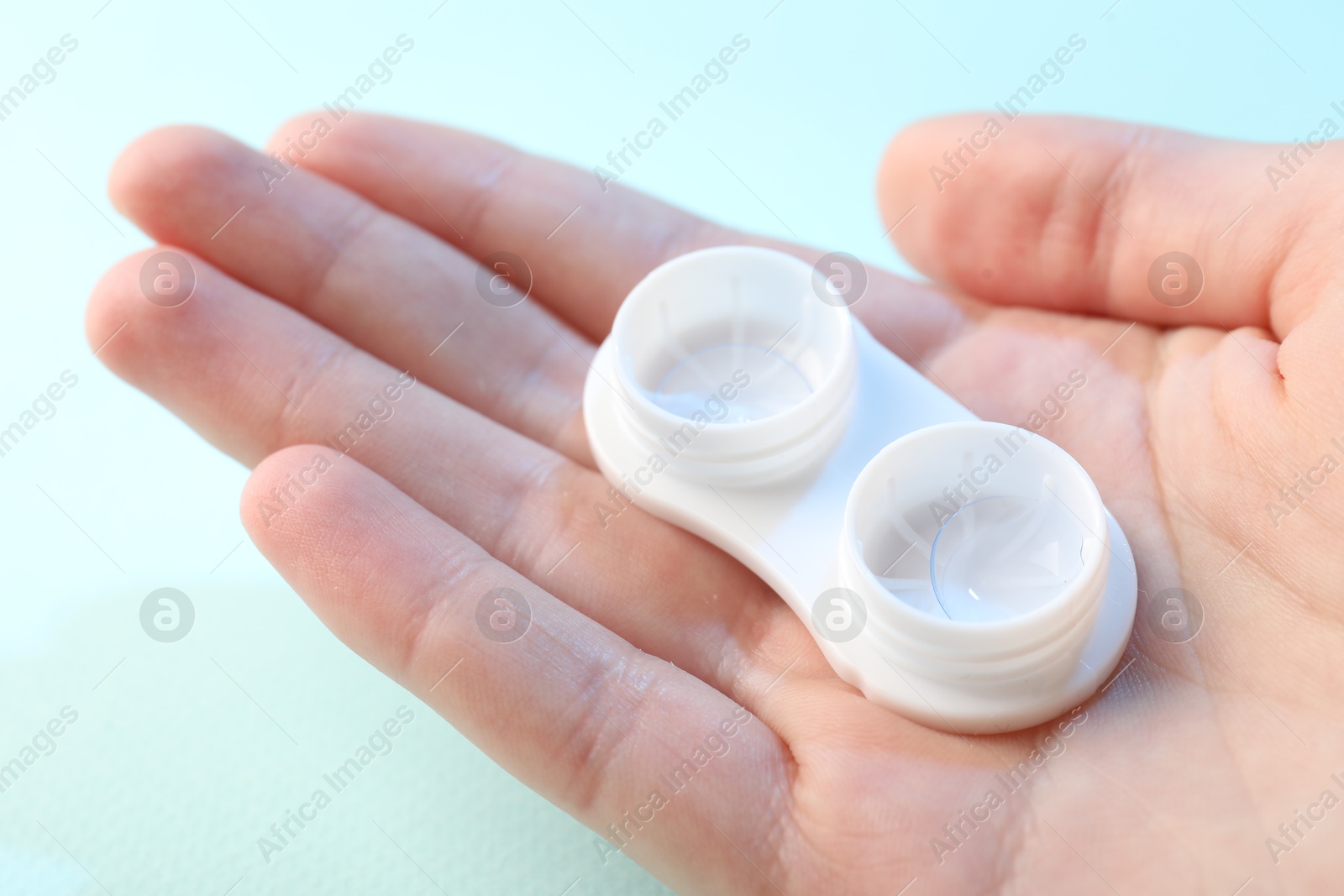 Woman with contact lenses on light blue background, closeup Photo of Woman with contact lenses on light blue background, closeup