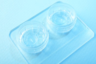 Photo of Case with contact lenses on light blue background, closeup