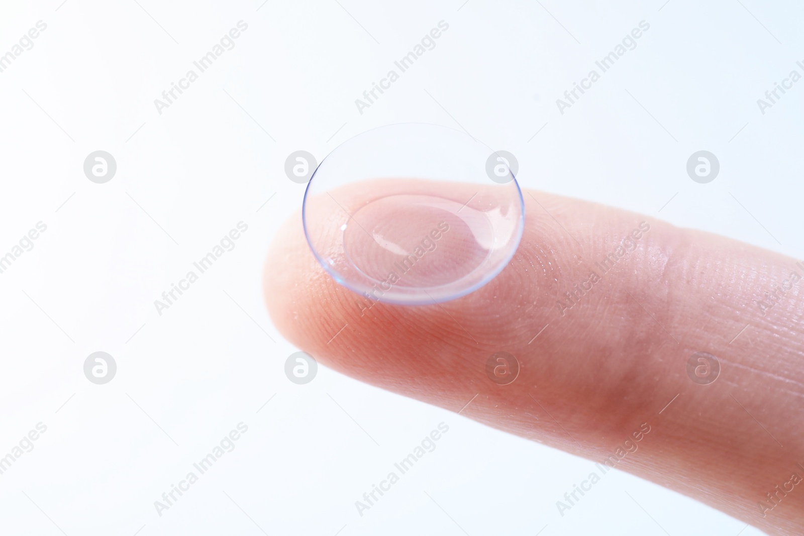 Woman with contact lens on light background, closeup Photo of Woman with contact lens on light background, closeup
