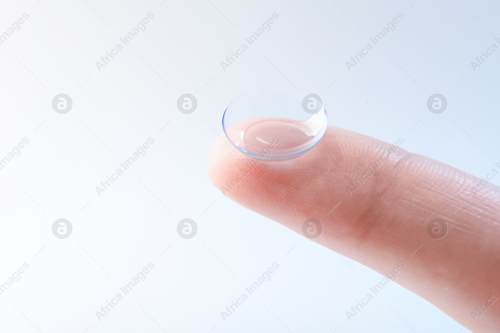 Woman with contact lens on light background, closeup. Space for text Photo of Woman with contact lens on light background, closeup. Space for text