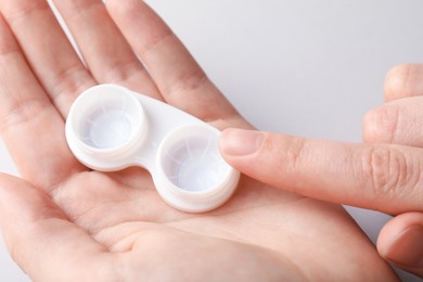 Photo of Woman with contact lenses on light background, closeup