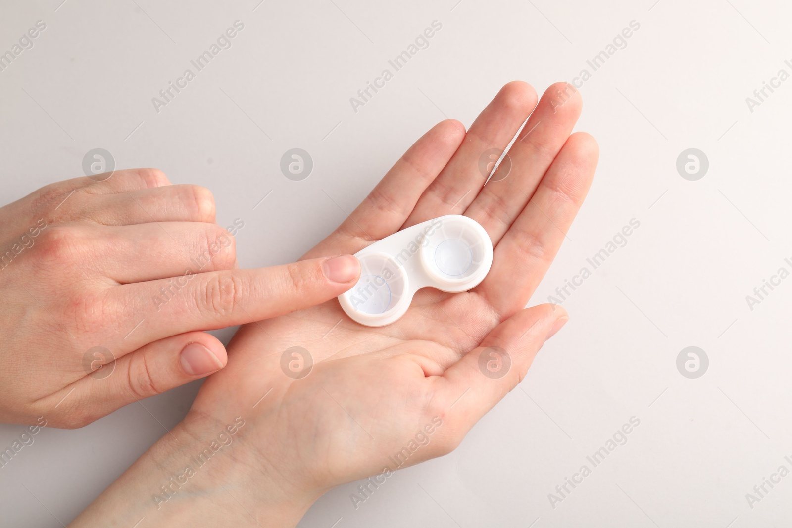 Woman with contact lenses on light background, top view Photo of Woman with contact lenses on light background, top view
