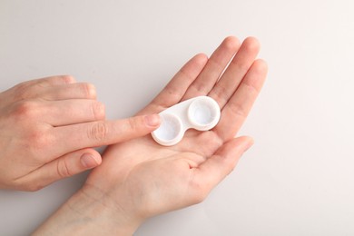 Photo of Woman with contact lenses on light background, top view