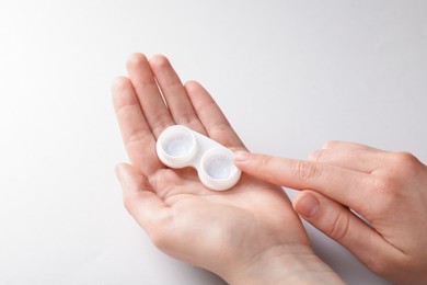 Photo of Woman with contact lenses on light background, closeup