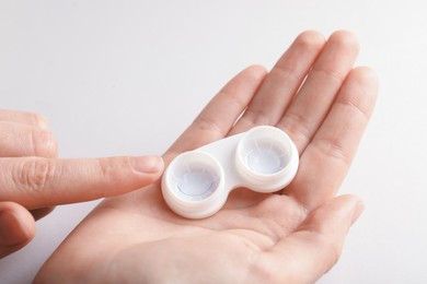 Photo of Woman with contact lenses on light background, closeup