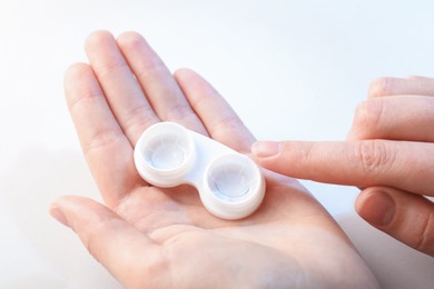 Photo of Woman with contact lenses on light background, closeup