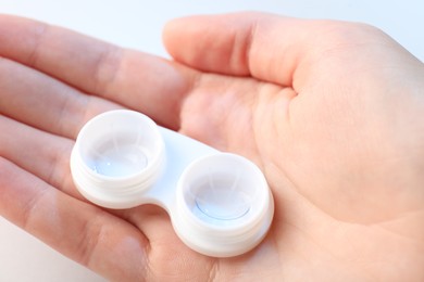 Photo of Woman with contact lenses on light background, closeup