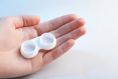 Photo of Woman with contact lenses on light background, closeup