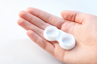 Photo of Woman with contact lenses on light background, closeup