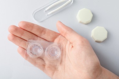 Photo of Woman with contact lenses on light background, flat lay